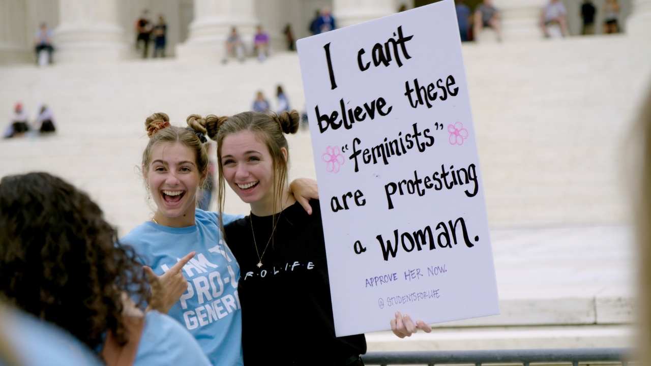 two women holding up a sign